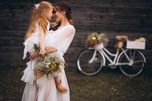 Madre con il suo bambino in bei vestiti con la bicicletta