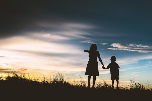 Madre con il suo figlio che punta verso l&#39;orizzonte