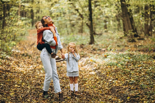 Madre con il suo piccolo figlio e figlia in un parco in autunno