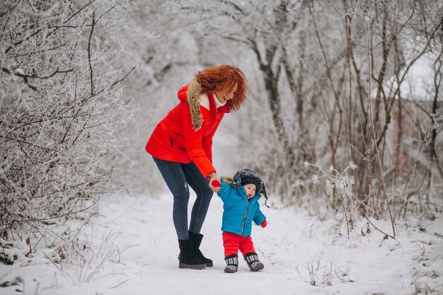 Madre con il suo piccolo figlio insieme in un parco d&#39;inverno