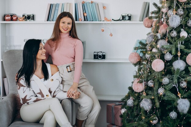 Madre con la figlia adulta con i regali di Natale dall'albero di Natale