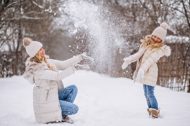 Madre con la figlia che cammina insieme in un parco di inverno