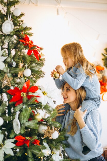 Madre con la figlia che decora l&#39;albero di Natale