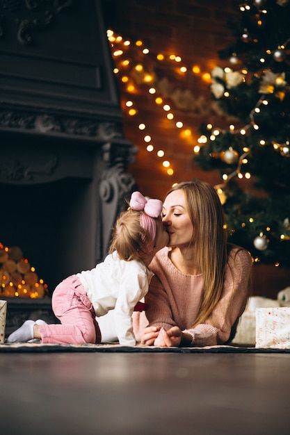 Madre con la figlia che disimballa i regali di Natale dall&#39;albero di Natale