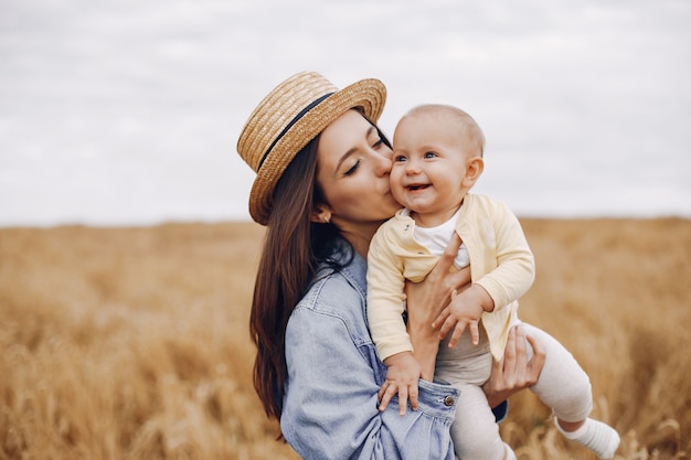 Madre con la figlia che gioca in un campo di autunno