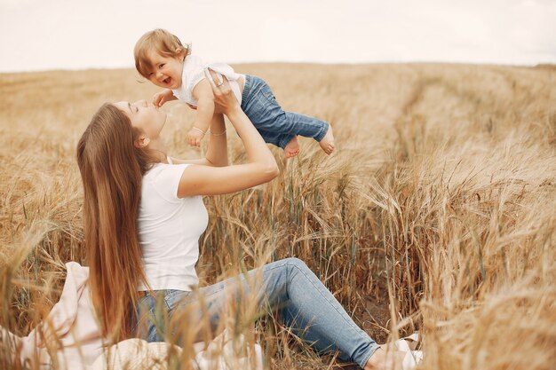 Madre con la figlia che gioca in un campo estivo