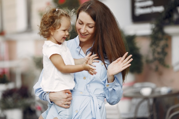 Madre con la figlia che gioca in una città di estate