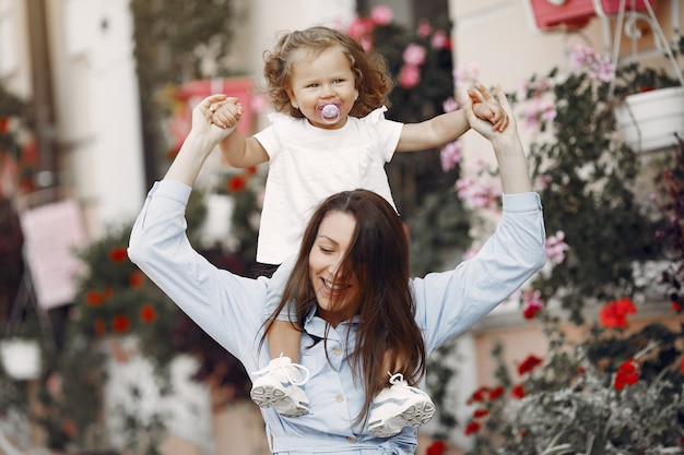 Madre con la figlia che gioca in una città di estate