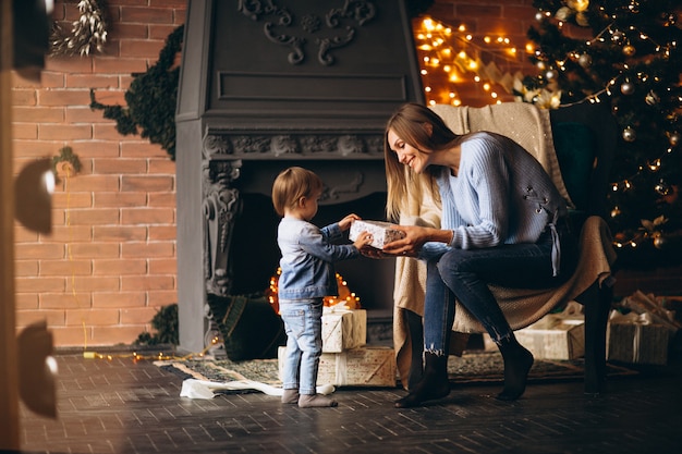 Madre con la figlia che si siede nella sedia dall&#39;albero di Natale