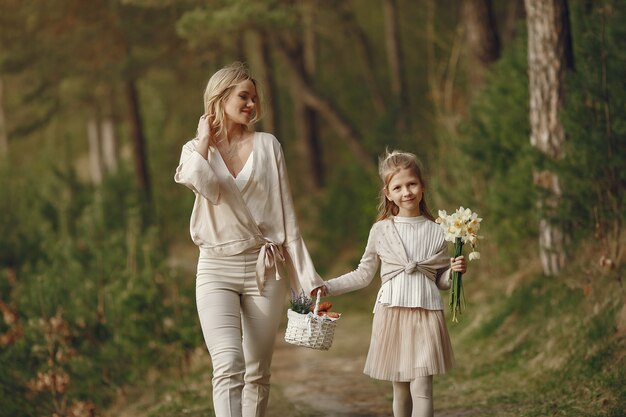 Madre con la figlia in una foresta di estate