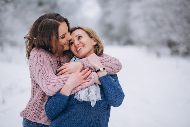 Madre con la figlia insieme nel parco di inverno