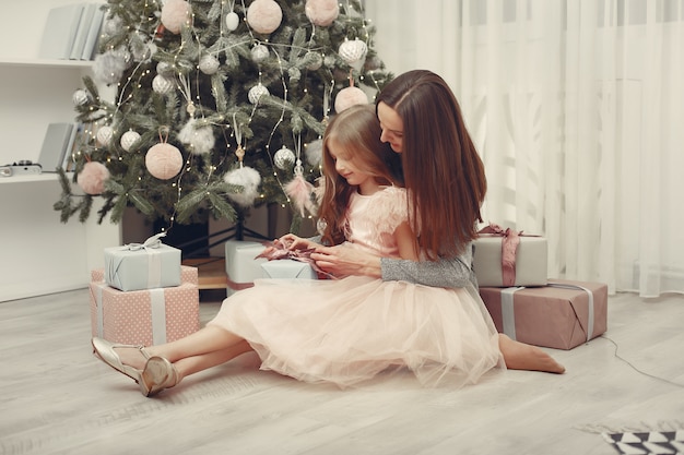 Madre con la figlia sveglia vicino all'albero di Natale