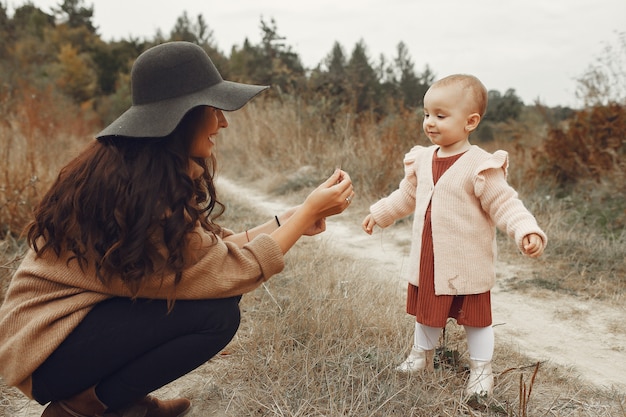 Madre con la piccola figlia che gioca in un campo di autunno