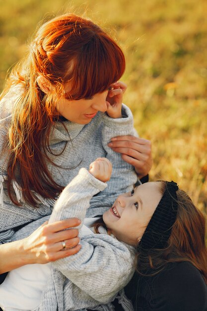 Madre con la piccola figlia che gioca in un campo di autunno