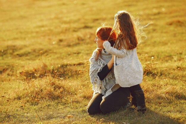 Madre con la piccola figlia che gioca in un campo di autunno