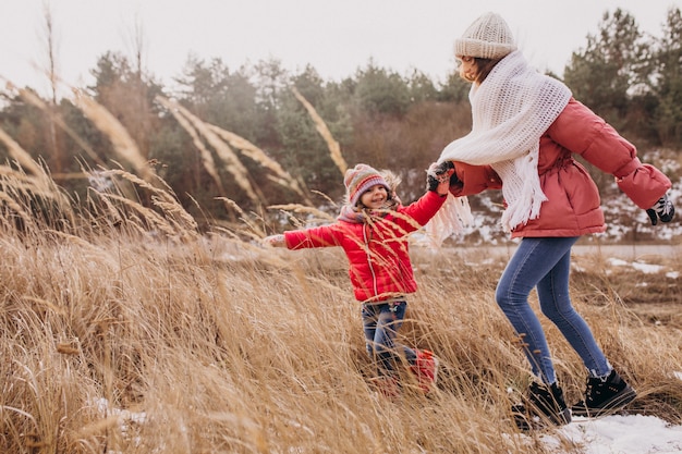 Madre con la piccola figlia in una foresta di inverno