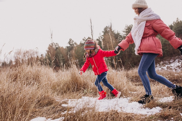 Madre con la piccola figlia in una foresta di inverno