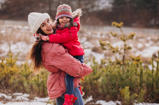 Madre con la piccola figlia in una foresta di inverno