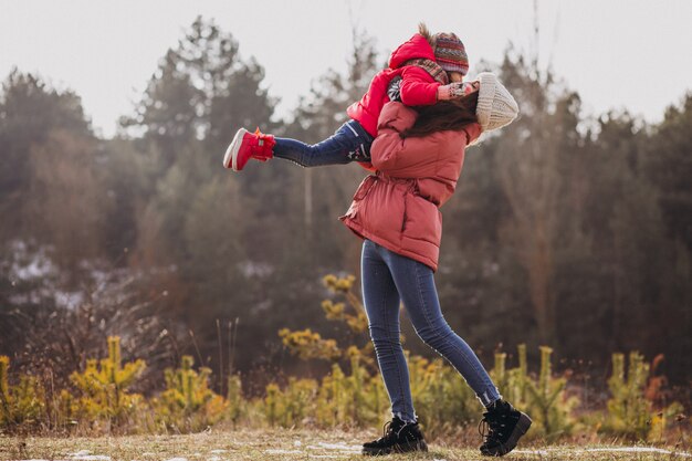 Madre con la piccola figlia in una foresta di inverno