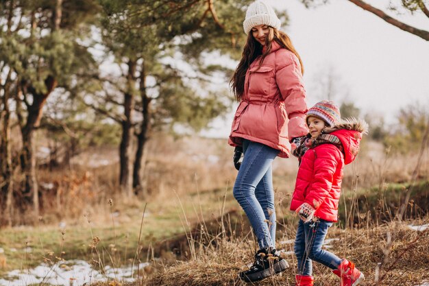 Madre con la piccola figlia in una foresta di inverno