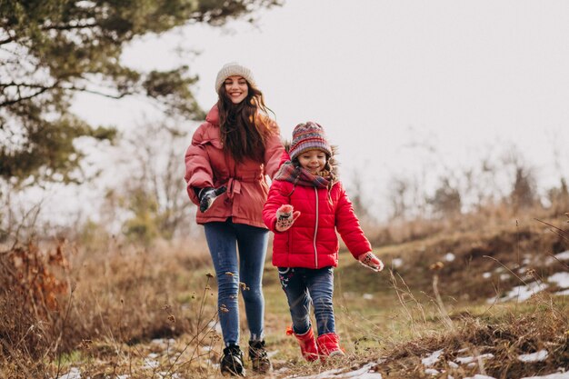 Madre con la piccola figlia in una foresta di inverno