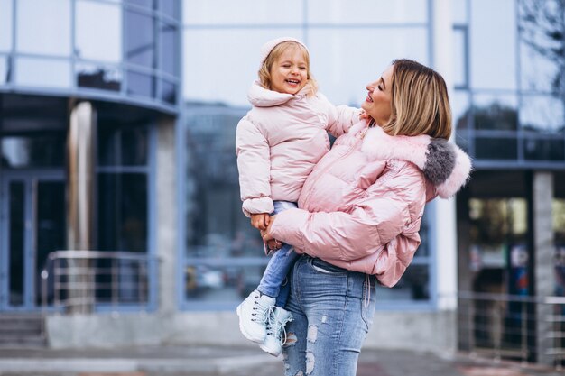 Madre con la sua piccola figlia vestita in panno caldo a lato della strada