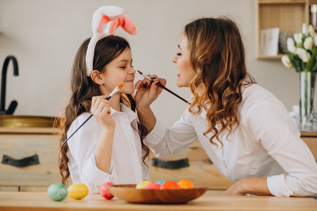 Madre con le uova della pittura della figlia per pasqua