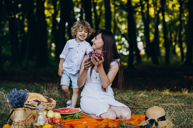 Madre con suo figlio che ha picnic nella foresta