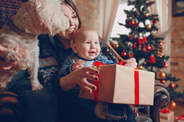 Madre con un bambino in braccio e questo con un regalo