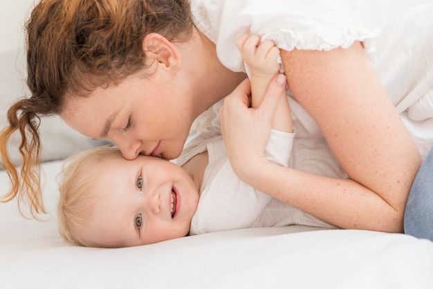 Madre del primo piano che bacia il suo bambino