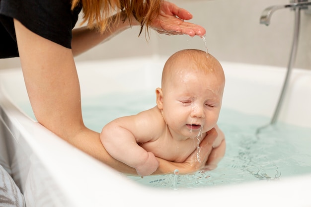 Madre del primo piano che lava il suo bambino