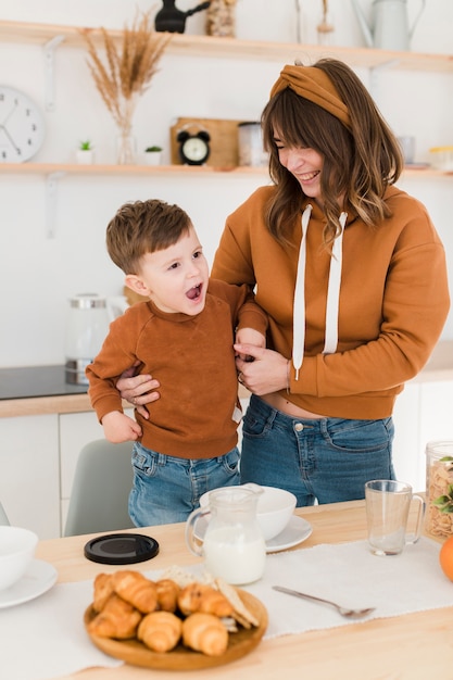 Madre dell'angolo alto con il bambino in cucina