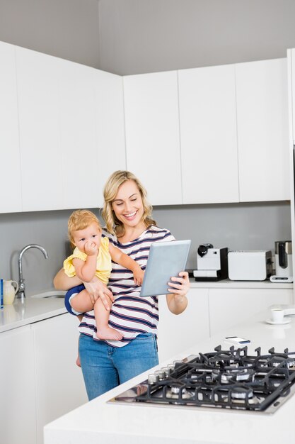 Madre e bambina con tavoletta digitale in cucina