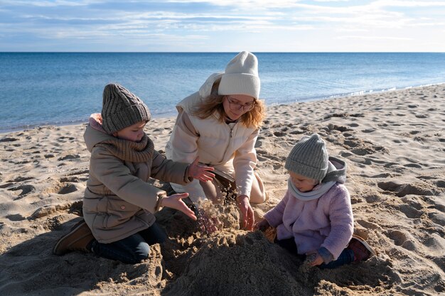 Madre e bambini a tutto campo in spiaggia