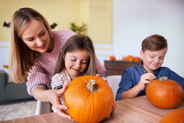 Madre e bambini che disegnano sulla zucca