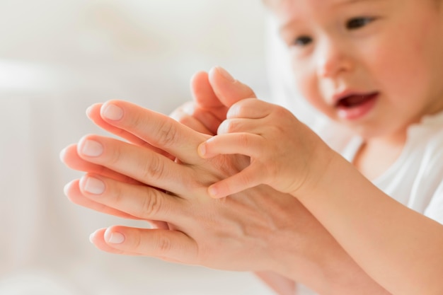 Madre e bambino del primo piano che giocano con le mani