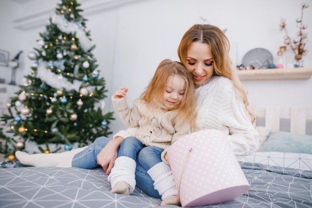 madre e bella bionda bambina apertura regali