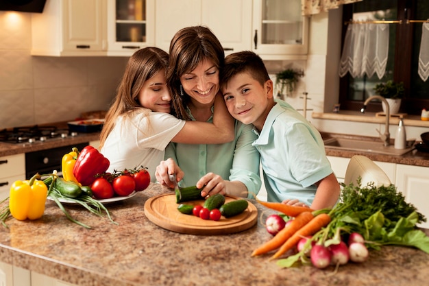 Madre e figli in cucina a preparare il cibo