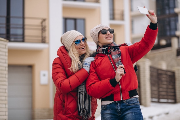 Madre e figlia che fanno selfie fuori in inverno
