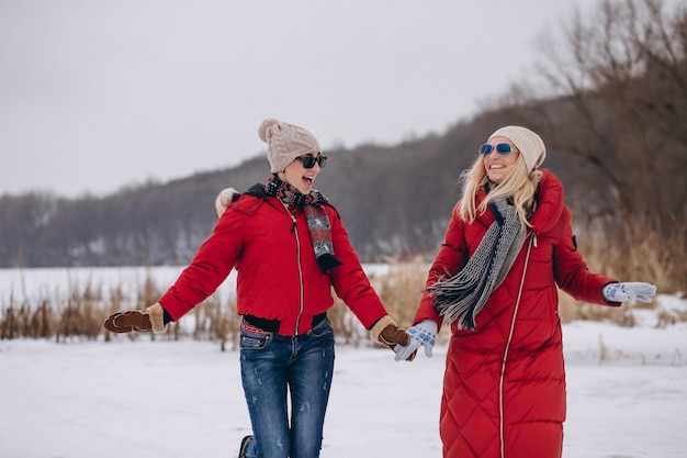 Madre e figlia che funzionano sul lago nell&#39;orario invernale