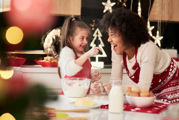 Madre e figlia che godono in cucina a Natale