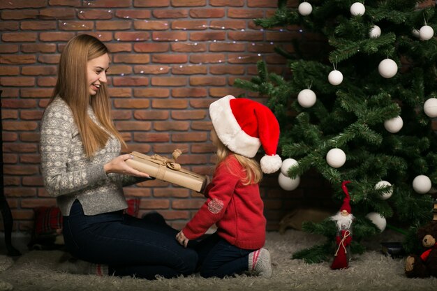 Madre e figlia che imballano i regali dall&#39;albero di Natale