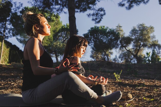 Madre e figlia che meditating nel parco