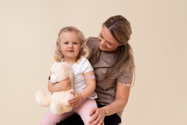 Madre e figlia che mostrano un adesivo sul braccio dopo aver ricevuto un vaccino