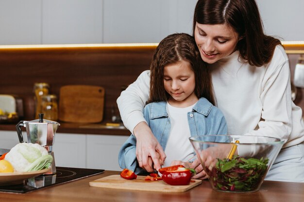 Madre e figlia che preparano il cibo in cucina