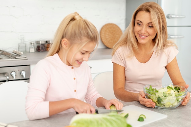 Madre e figlia che preparano insalata