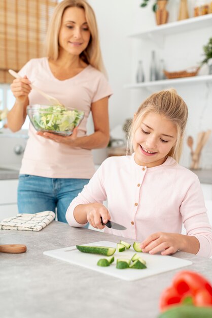 Madre e figlia che preparano insalata
