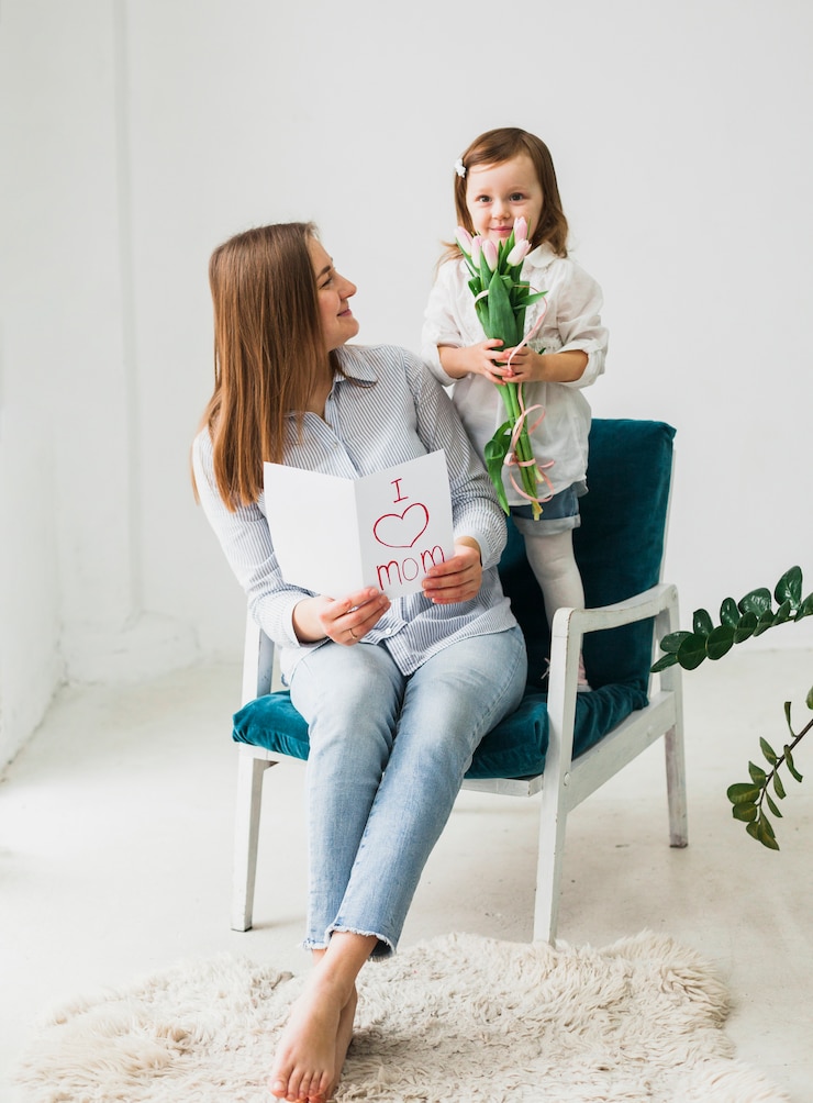 Foto gratuito madre e figlia che si siedono con la cartolina d&#39;auguri