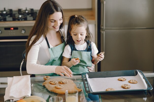 Madre e figlia che si siedono in una cucina con i biscotti