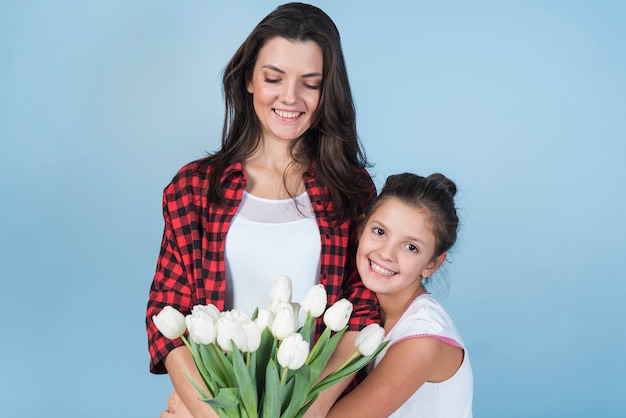 Madre e figlia che tengono i tulipani bianchi
